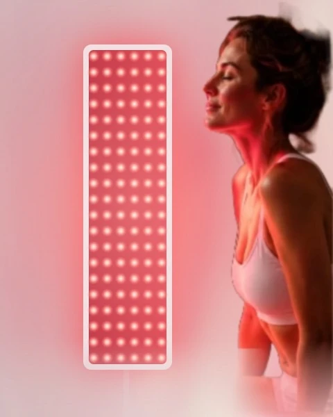 Woman relaxing in front of a glowing red light therapy panel